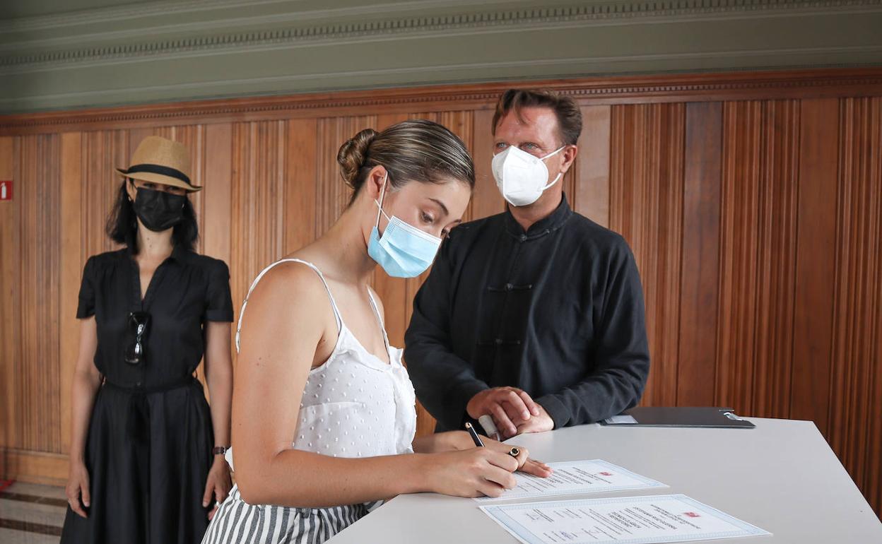 La joven grancanaria firma la beca. 