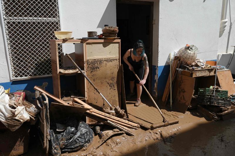 Una mujer limpia su terraza tras el temporal que ha destrozado Alcanar (Tarragona)