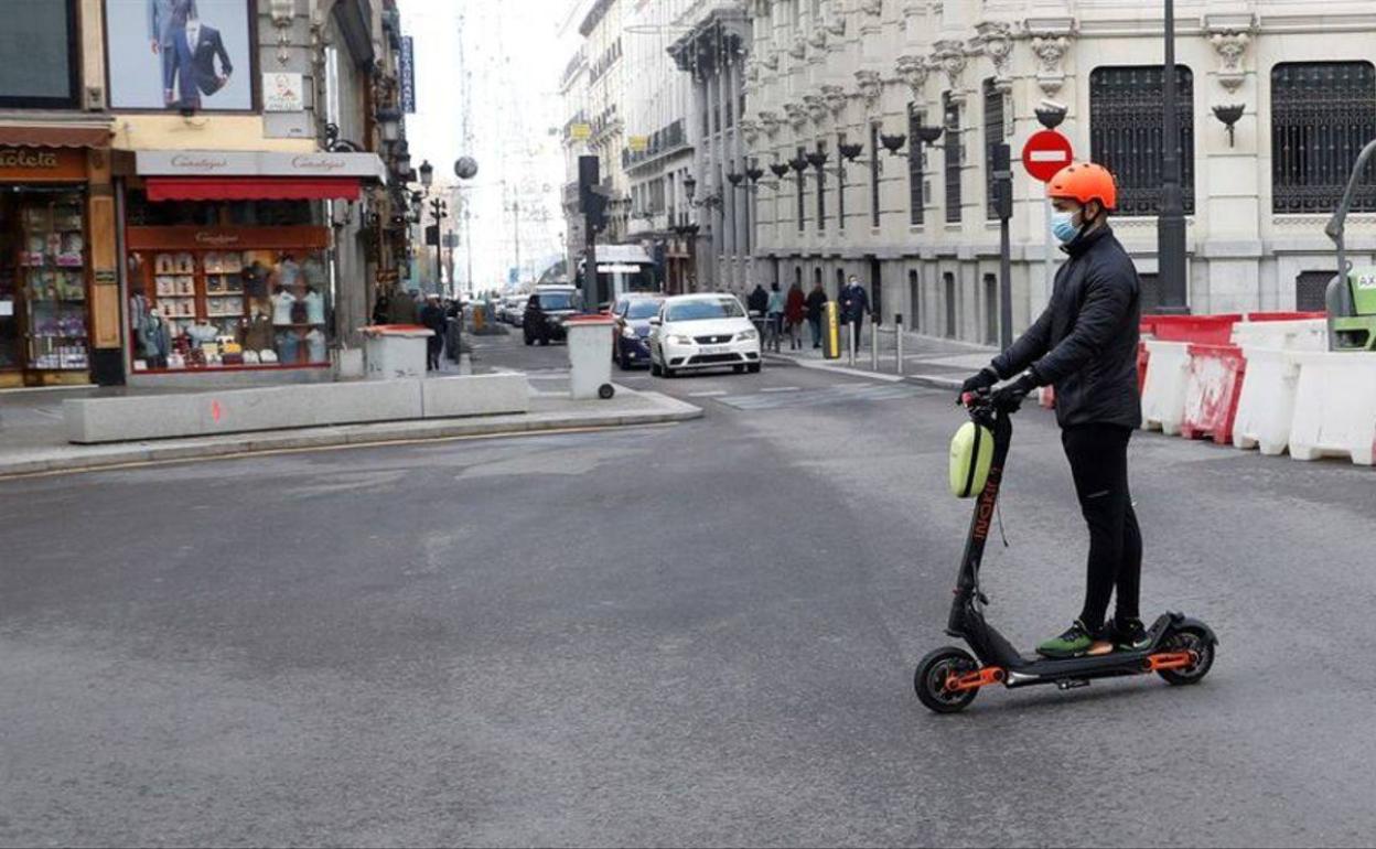 Imagen de archivo de una persona en patinete eléctrico. 