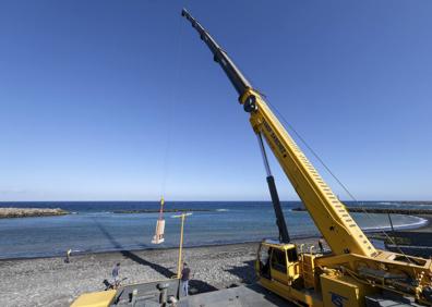 Imagen secundaria 1 - Arriba, familiares de la homenajeada y cargos públicos de Santa Lucía tras el acto. Abajo, un momento del dispositivo, con la grúa cargando el conjunto de la piedra grande y la escultura. El conjunto pesa 5.700 kilos. Al lado, la niña Isabel, el día de su comunión (foto cedida por la familia).