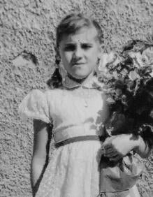 Imagen secundaria 2 - Arriba, familiares de la homenajeada y cargos públicos de Santa Lucía tras el acto. Abajo, un momento del dispositivo, con la grúa cargando el conjunto de la piedra grande y la escultura. El conjunto pesa 5.700 kilos. Al lado, la niña Isabel, el día de su comunión (foto cedida por la familia).