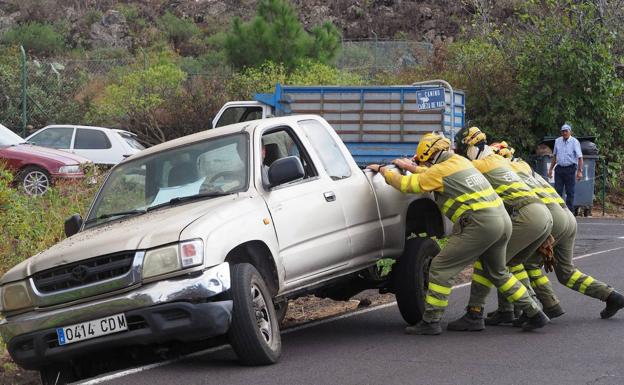 Operarios de emergencia ayuda a un coche a volver a la carretera. 
