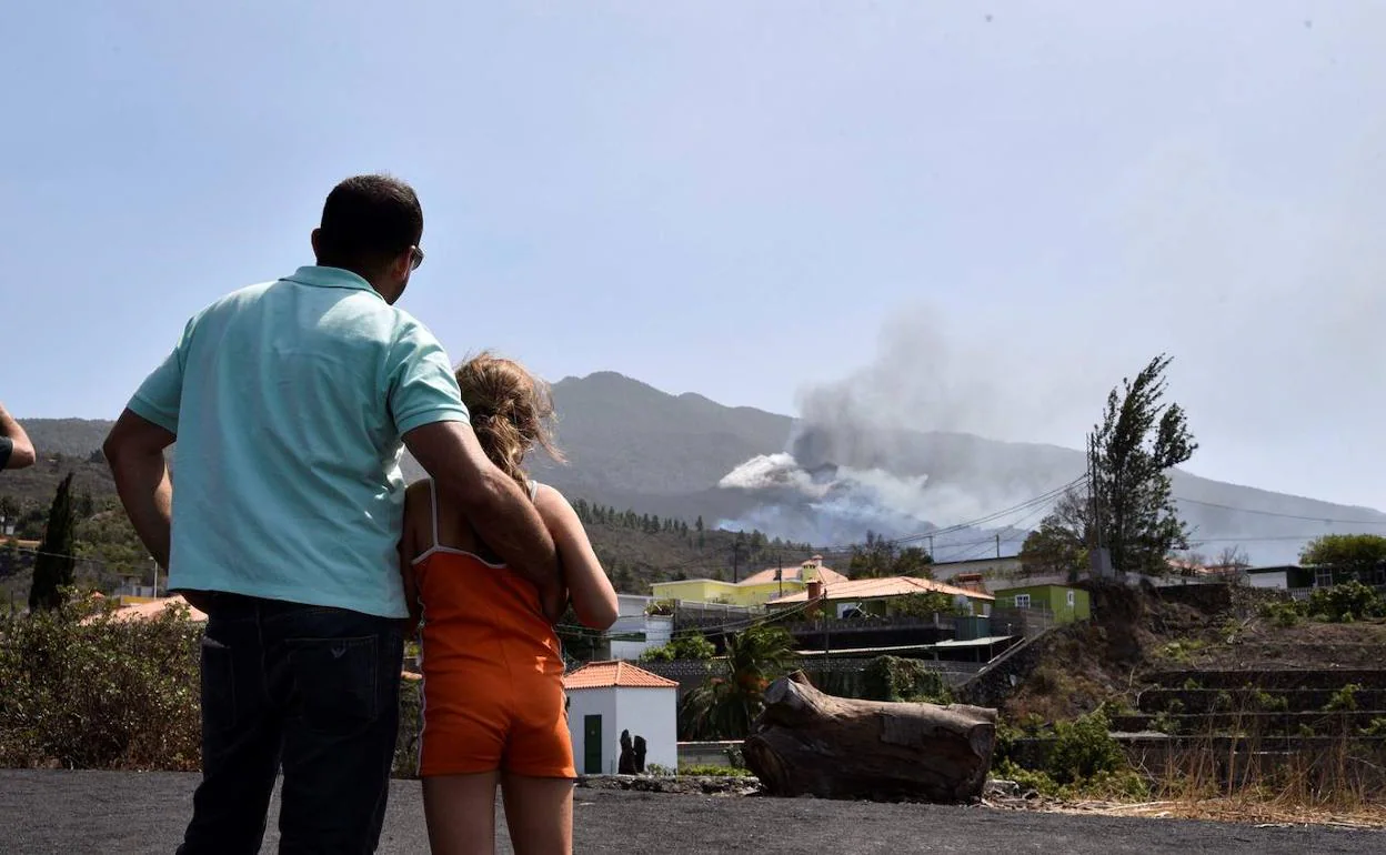 Varias personas observan el volcán de Cumbre Vieja. 