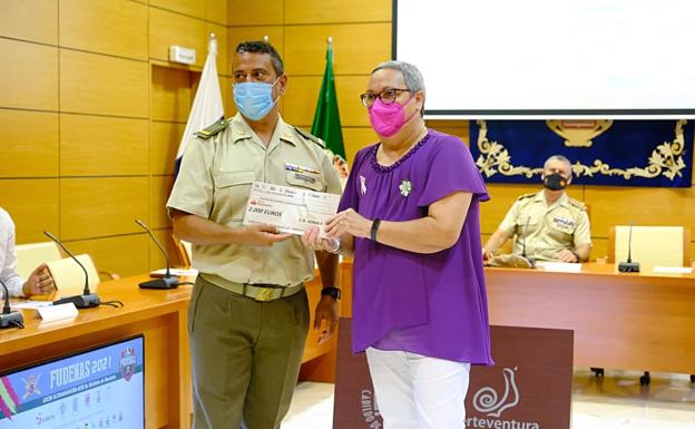 Gregorio Hernández, presidente del club deportivo Soria 9, entrega el cheque solidario a Isabel Laucirica, presidenta de la AECC, bajo la mirada del coronel jefe Alberto Guevara. 