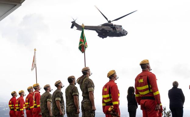 Los militares presencian el momento en que el helicóptero participa en el homenaje.