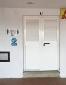 Imagen secundaria 2 - Arriba, un empleado del Golden Beach improvisando unas sillas-hamacas para sus clientes. Abajo, trabajadores retirando de la arena las tumbonas que habían apilado el miércoles, y estampa de los aseos cerrados a cal y canto. 