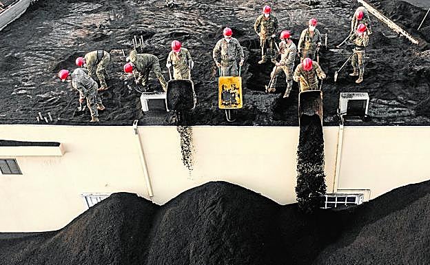 Efectivos del Ejército de Tierra se afanan en retirar la ceniza de una casa de Las Manchas el pasado miércoles. 