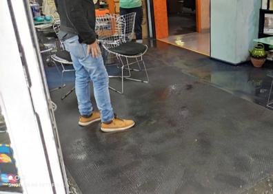 Imagen secundaria 1 - Charcos en la calle Buenos Aires esquina Pérez Galdós. El interior de la Óptica Checa con agua