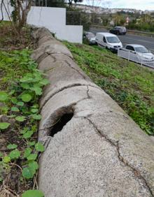 Imagen secundaria 2 - Arriba, Agustín Sosa señala el estado de su muro. Sobre estas líneas, la tubería que cree origina el problema.