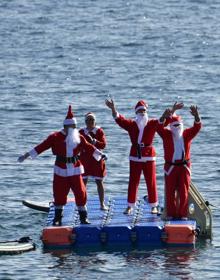 Imagen secundaria 2 - Papá Noel llega a Arinaga haciendo paddle surf