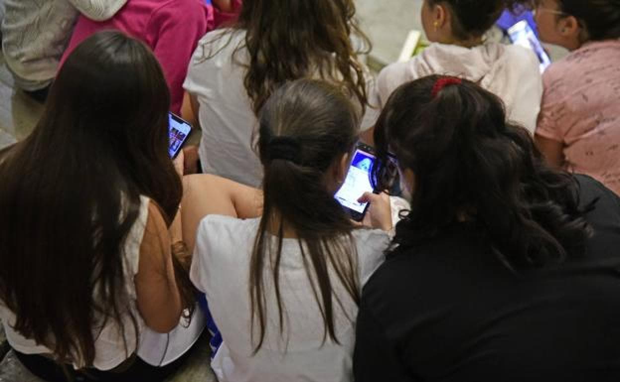 Jóvenes consultando información en sus móviles. 