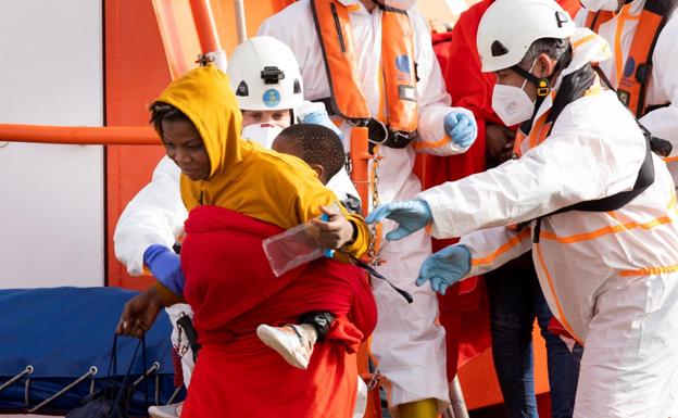 Una mujer baja con un hijo de la embarcación de Salvamento Marítimo tras su rescate al sur de Gran Canaria. 