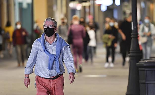 Un transeúnte con mascarilla, en la noche de este viernes. 