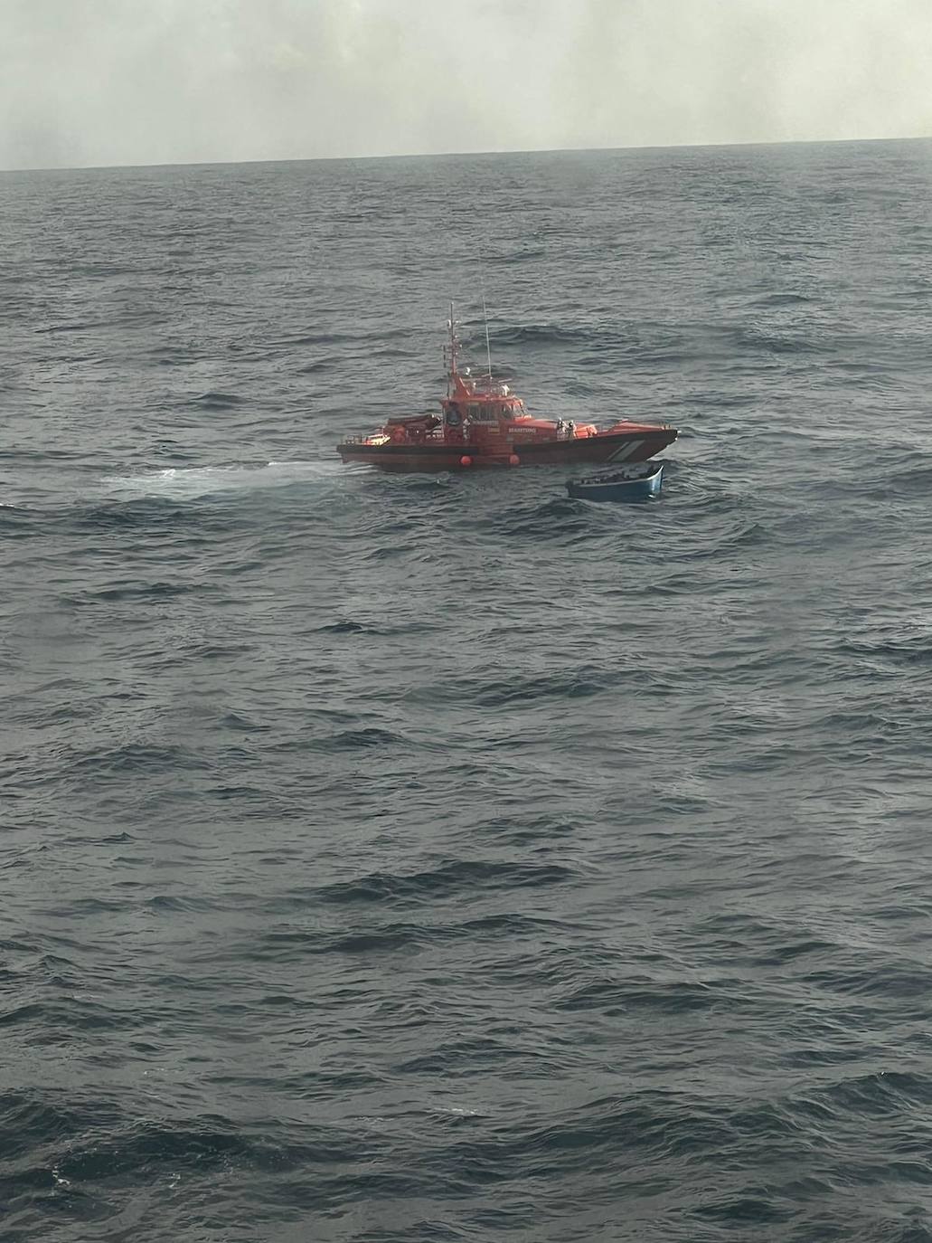 La embarcación de salvamento y la patera vistas desde la cubierta del ferry de Naviera Armas. 