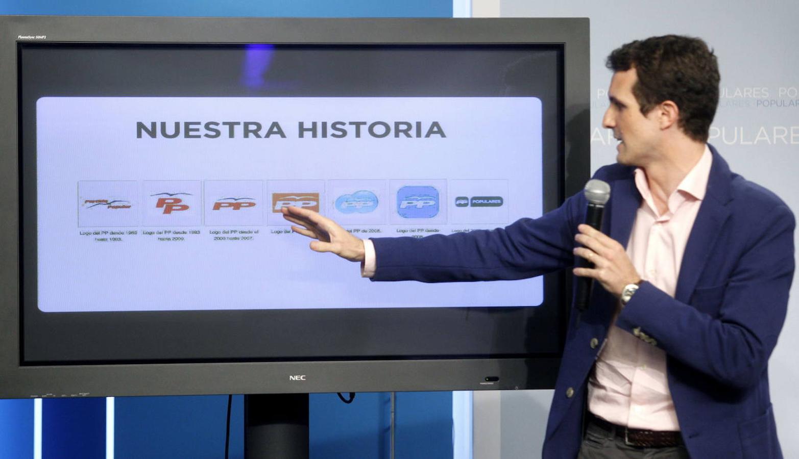 El ya vicesecretario de Comunicación del PP, Pablo Casado muestra en una pantalla la evolución cronológica de los sucesivos logotipos del Partido Popular.