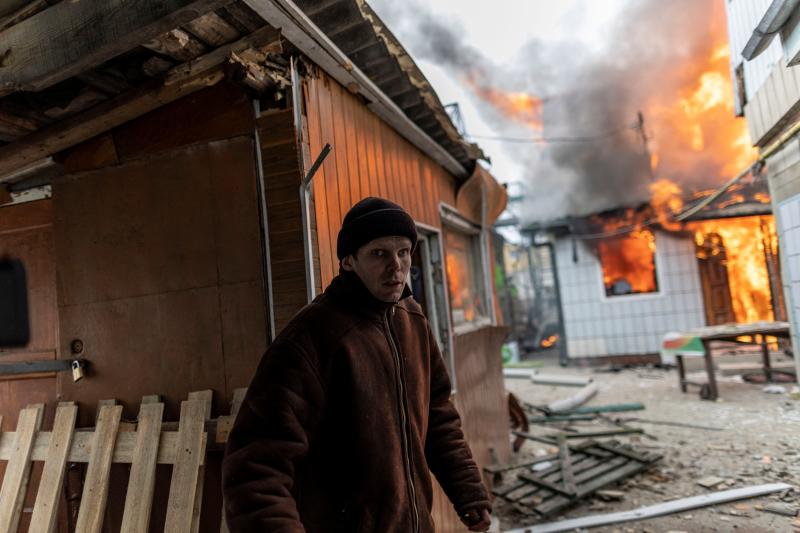 Un hombre intenta salir de una de las viviendas bombarfdeadas en la ciudad del Irpin, a 24 kilómetros de Kiev. 