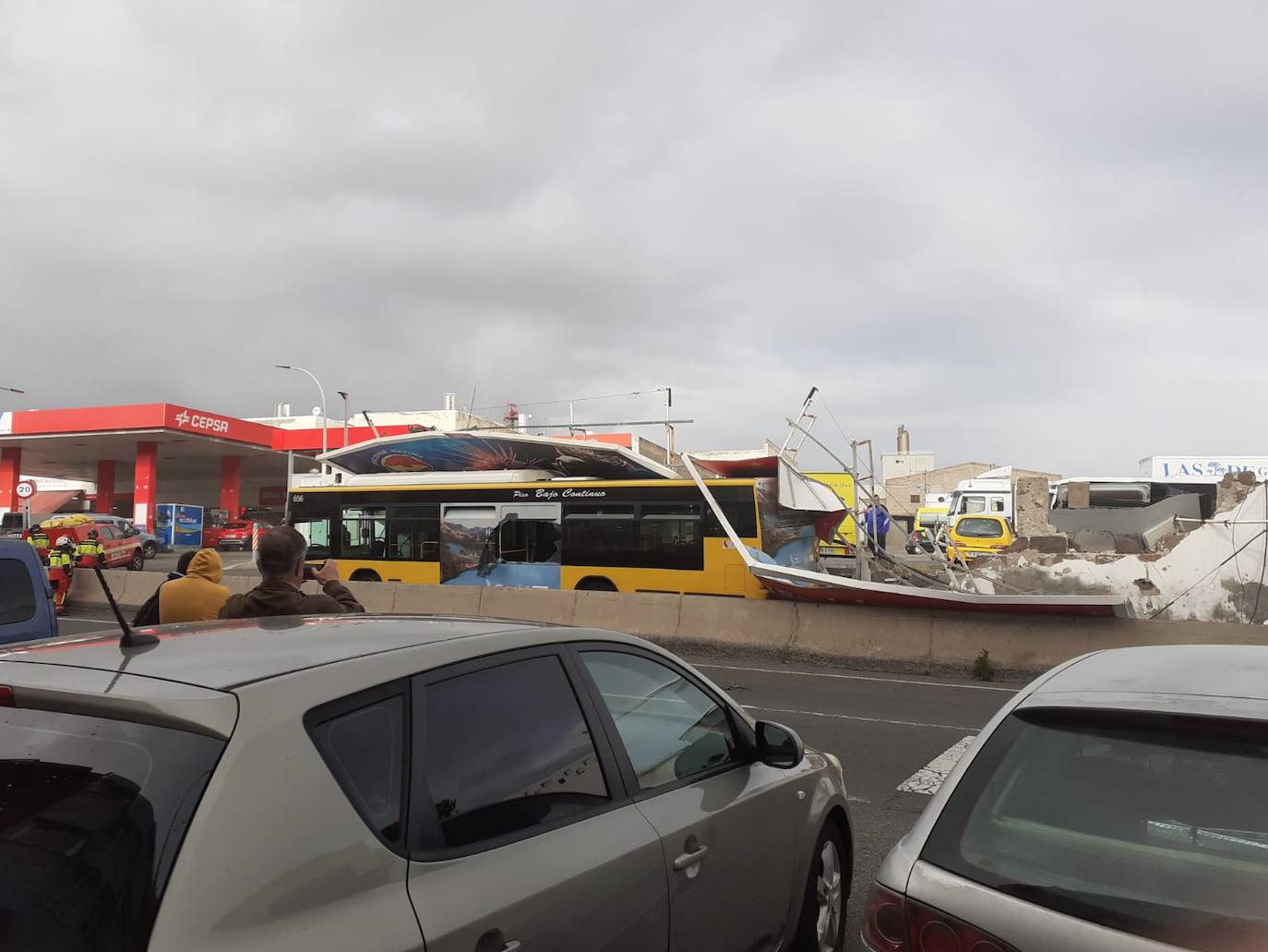 Imagen secundaria 1 - Cae un muro con una valla publicitaria sobre una guagua en El Cardón