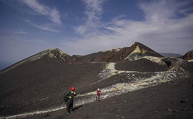 Foto de archivo de dos científicos del IGN caminando por el cráter del volcán palmero. 