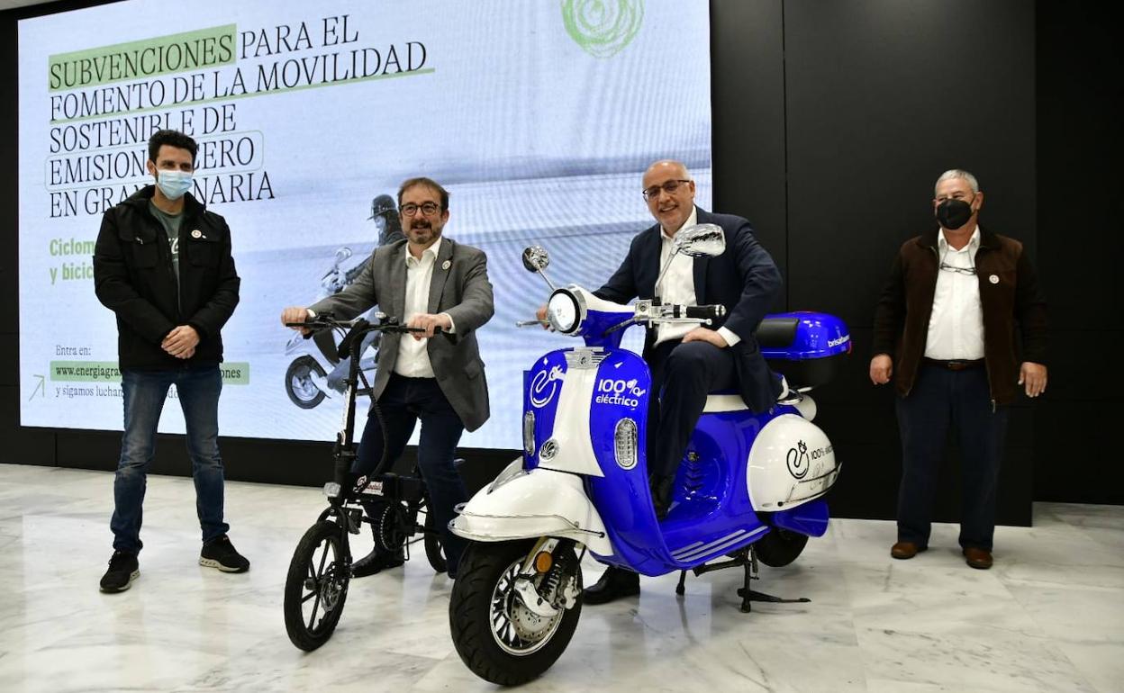 El presidente del Cabildo sobre un ciclomotor eléctrico. A su lado, Raúl García, en una bicicleta. 