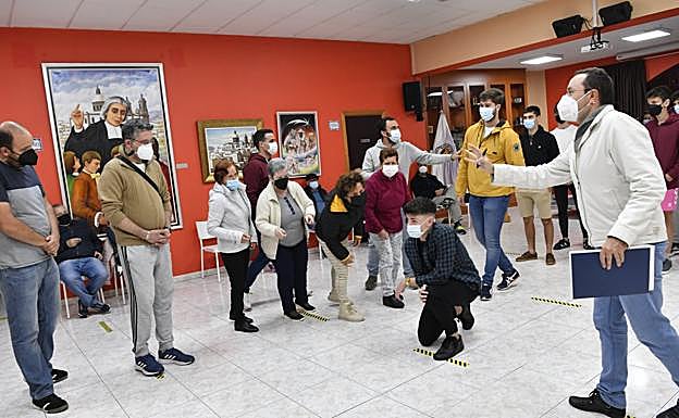 Jesús (Raúl), arrodillado, en la puesta en escena de una de las caídas de Cristo en su camino a El Calvario, mientras el pueblo hebreo le increpa. Luis da indicaciones. 
