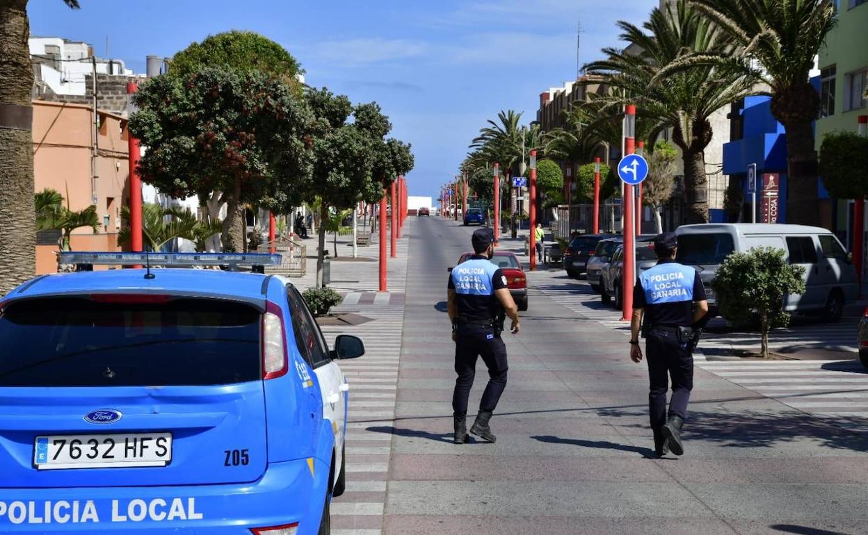 Dos agentes de patrulla por Playa de Arinaga. 