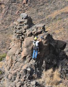 Imagen secundaria 2 - Acceso de la cueva, zona delimitada en el interior y uno de los trabajadores en lo alto del talud. 