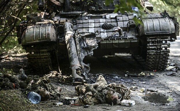 Soldados ucranianos yacen junto a un tanque destruido en las cercanías de la ciudad de Donetsk, al este del país. 