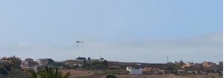 Un helicóptero descarga agua sobre la zona afectada.