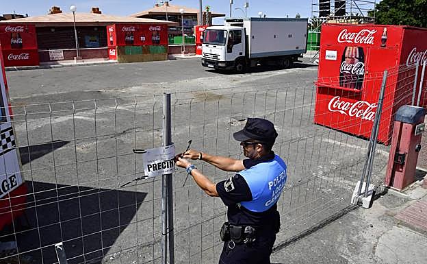 Momento en que un policía local precinta uno de los aparcamientos. 