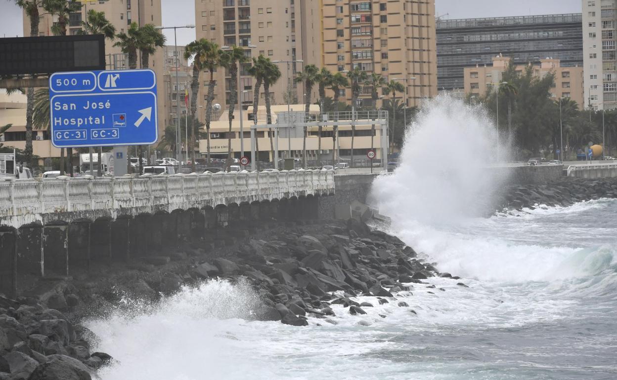 Imagen del mar golpeando las bases que sostienen el paseo marítimo. 