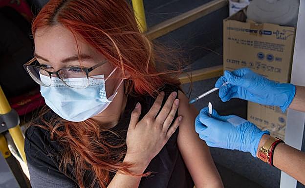 Una joven se vacuna contra la covid en la unidad móvil Vacuguagua. 