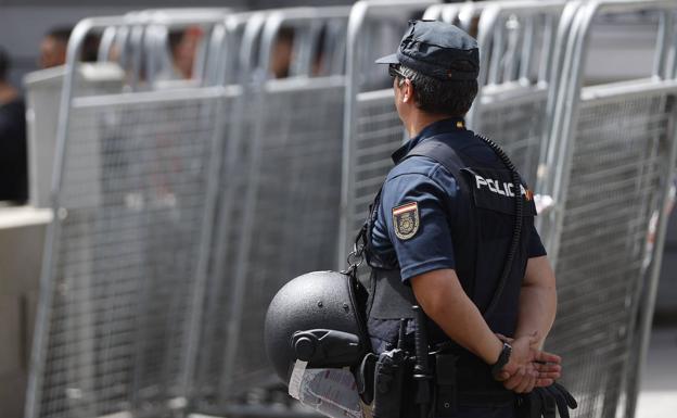 Un policía vigila junto a varias vallas de seguridad en Madrid.