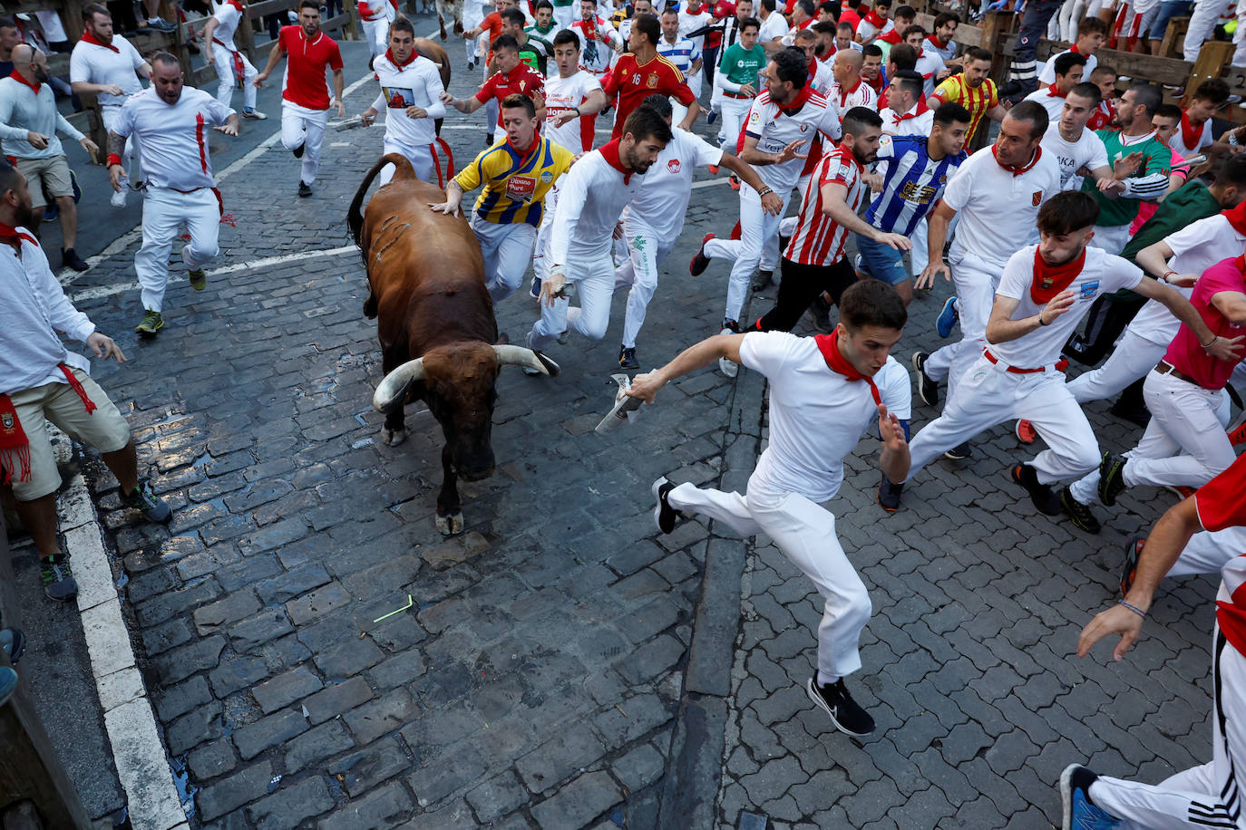 Los mozos corren ante los toros de la ganadería de José Cebada Gago durante el quinto el encierro de San Fermín. 