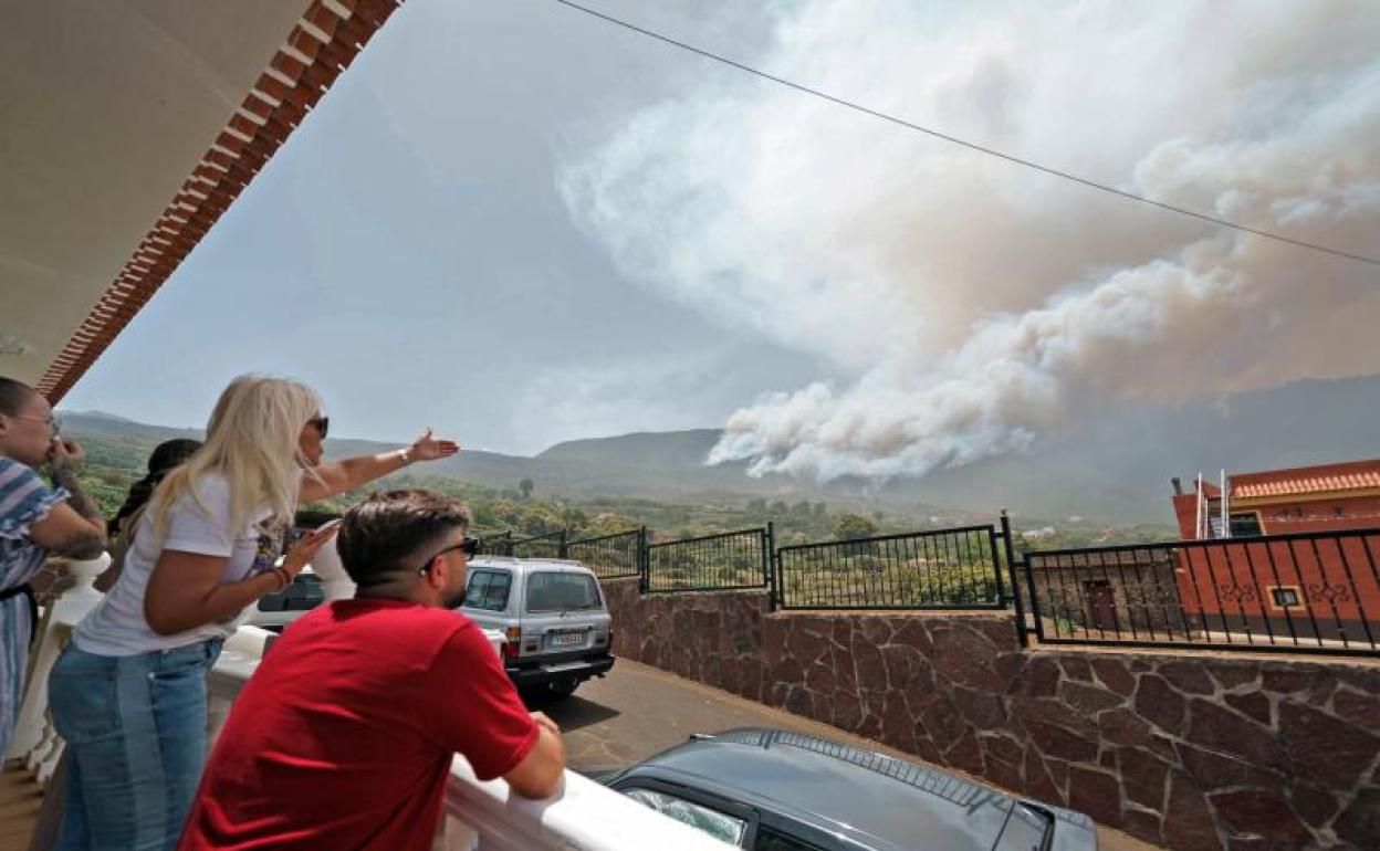 Vecinos del barrio de Las Llanadas, en el municipio tinerfeño de Los Realejos, observan el incendio que afecta al norte de la isla. 