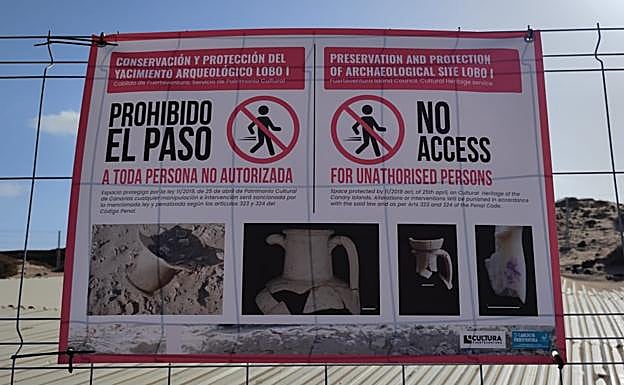 Cartel en inglés y español sobre la prohibición de entrar en el yacimiento. 