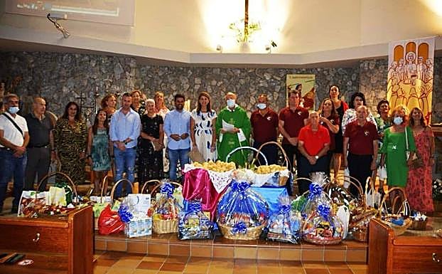 Imagen principal - Profesionales del sector y cargos públicos municipales posan con el párroco tras la misa a Santa Marta. 