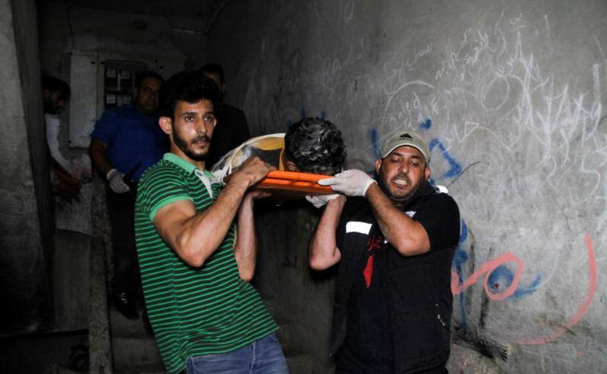Miembros del Servicio Humanitario de la Defensa Civil Palestina trasladan a un herido en la Franja de Gaza