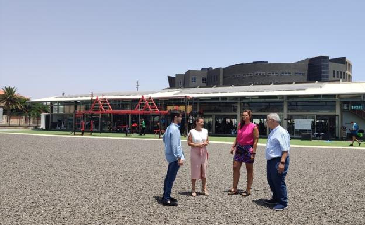 Concejalas y directivos de Lude Servicios, con las placas solares en el techo de la piscina, en la parcela anexa que se destinará a entrenamientos dirigidos. 