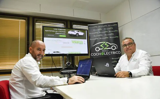 Roberto Amorín y Alfonso Rincón delante de una pantalla con la 'home' de su web. 