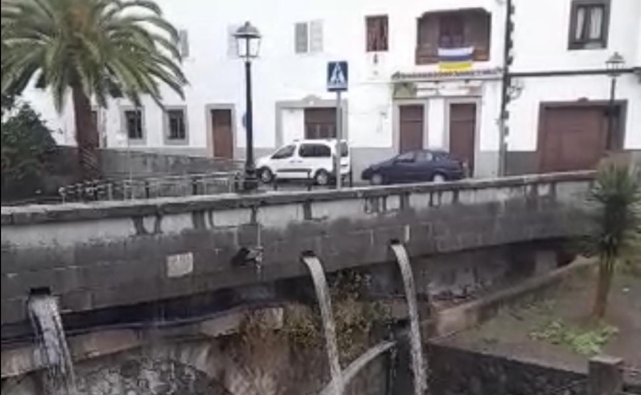 El agua cayendo en el puente de Teror, en el casco. 