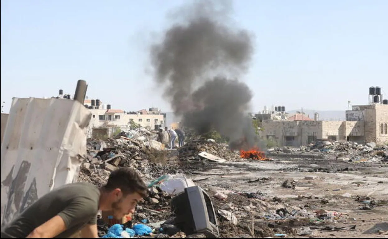 Un palestino se pone a cubierto durante los enfrentamientos con las tropas israelíes en Yenín. 