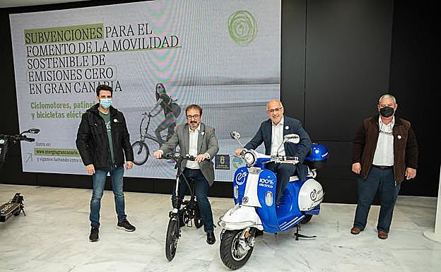 El presidente del Cabildo en un ciclomotor eléctrico y el coordinador de Clima sobre una bicicleta. 
