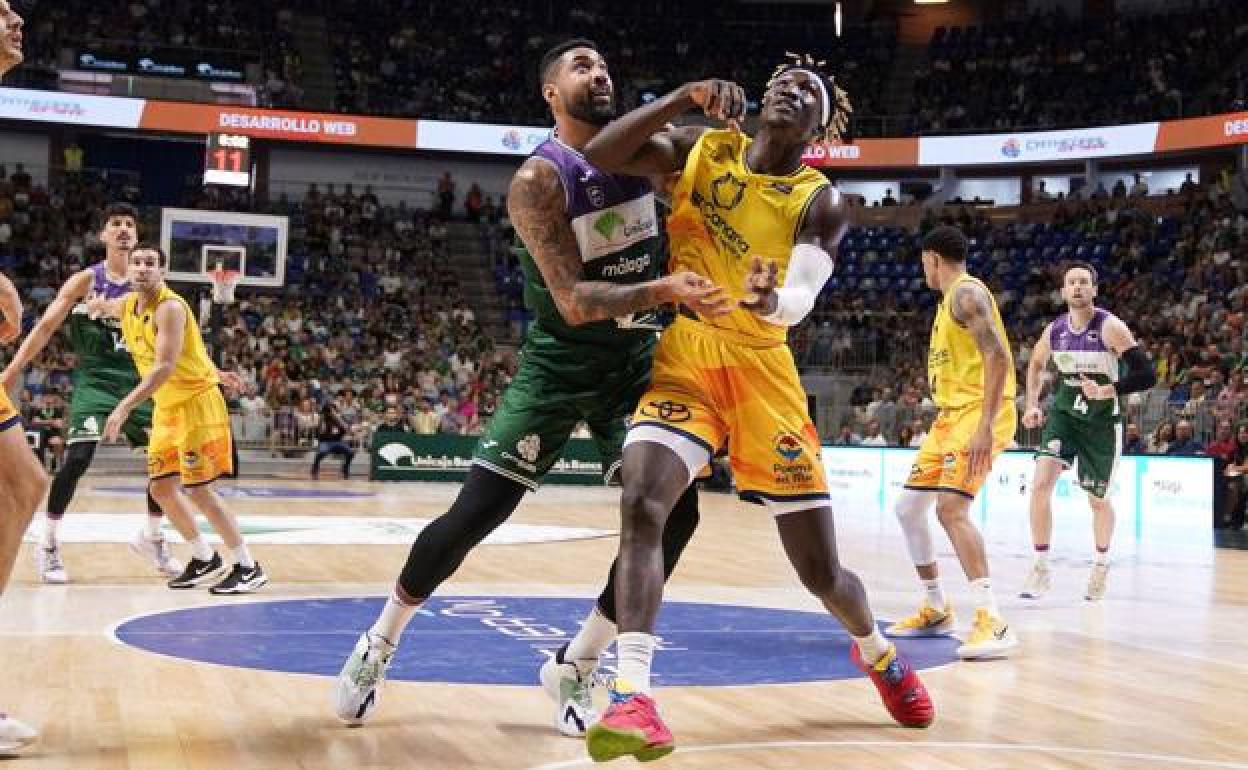 Khalifa Diop peleando un rebote contra un contrincante. 