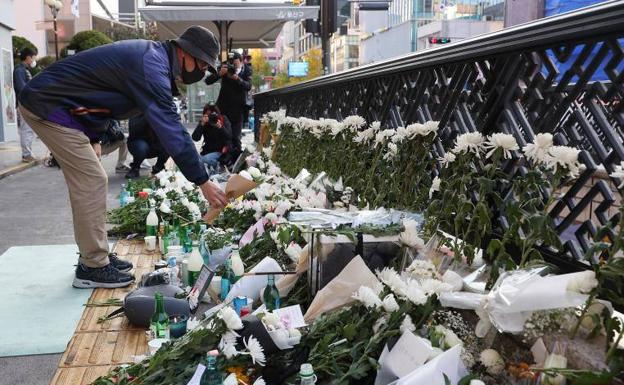 Un hombre deposita una flor en un memorial situado en la zona de bares donde tuvo lugar la tragedia el sábado.
