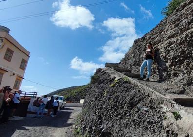 Imagen secundaria 1 - José Taisma, en la foto superior, muestra el último desprendimiento. Soraya Delgado, en la imagen inferior izquierda, accede a su casa por los escalones abiertos en el risco. Y Juan y María del Carmen, en la de la derecha, en el acceso a su casa. 