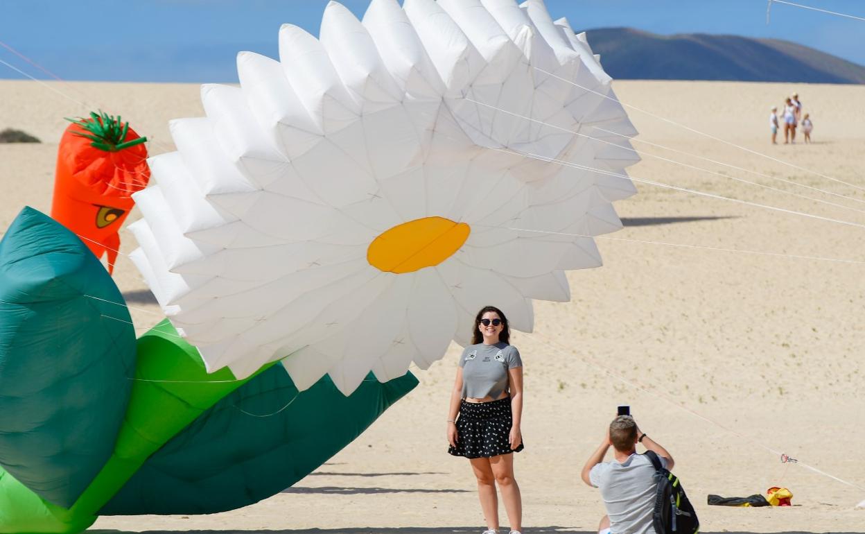 Una pareja se hace una foto con una de las cometas que ensayan estos días en las Dunas de Corralejo. 