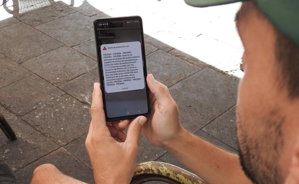 Un joven revisa su móvil en Garachico tras recibir la alerta de prueba. 