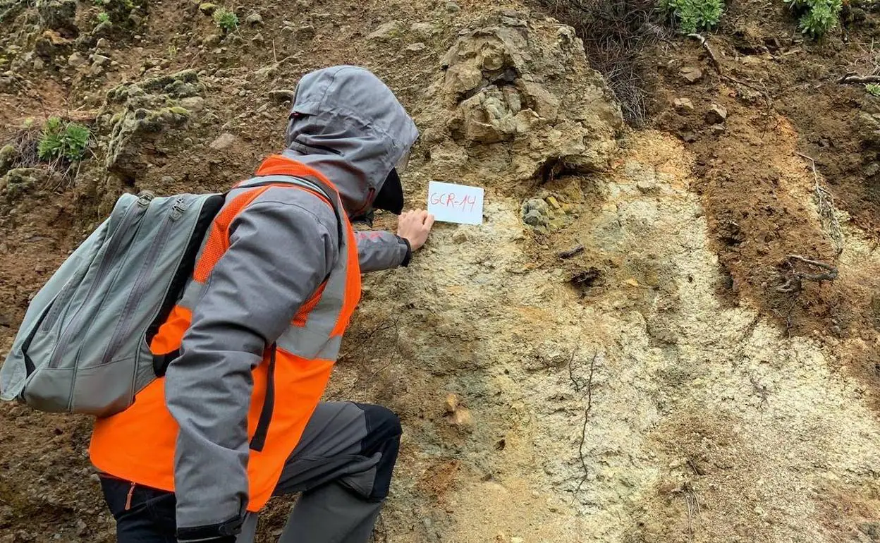 Un participante en la toma de muestras de rocas superficiales señala el punto de recogida. 