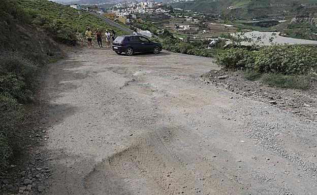 Estado de la carretera por la que se llega a medio centenar de viviendas. 