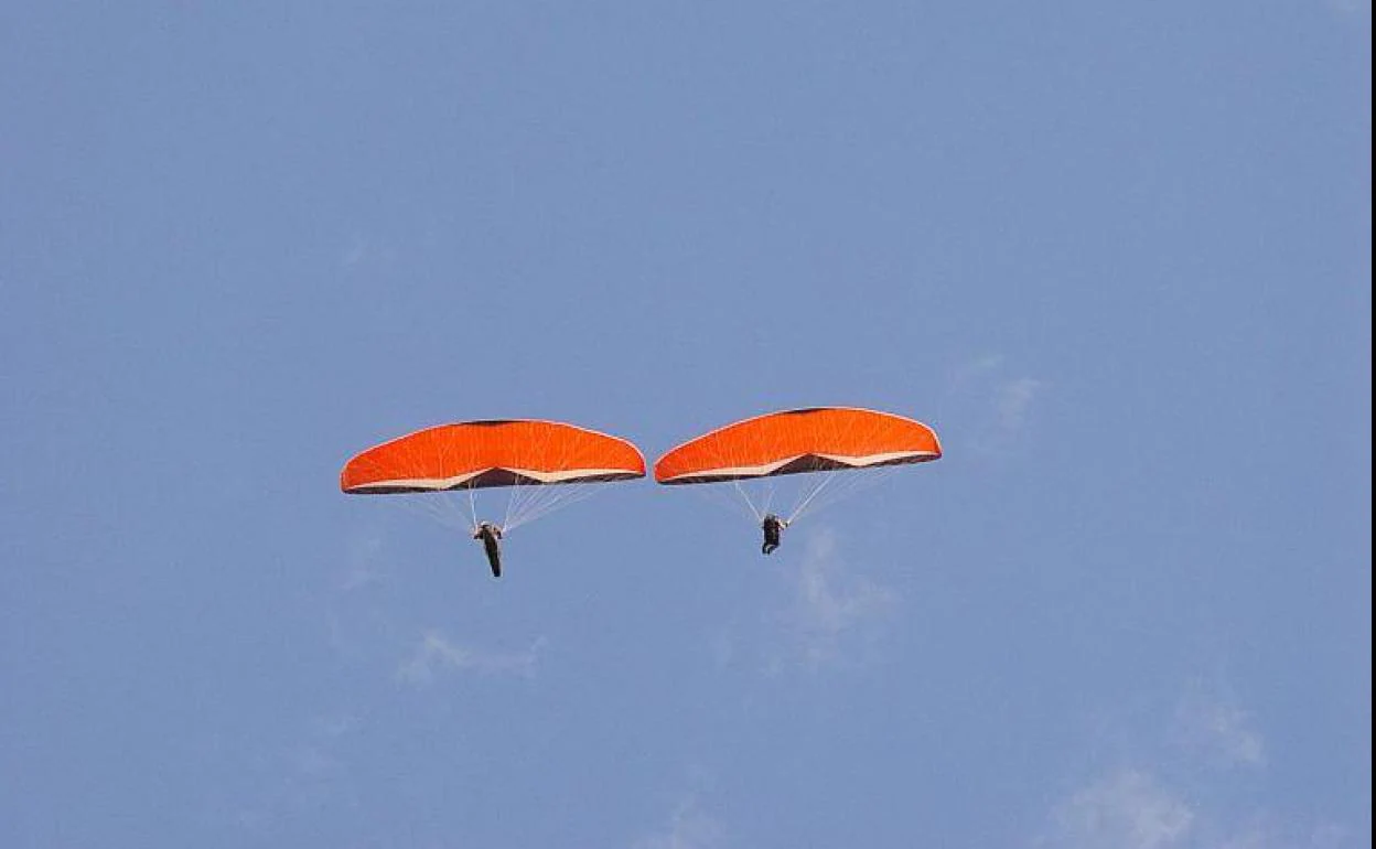 Imagen de archivo de dos personas practicando parapente. 